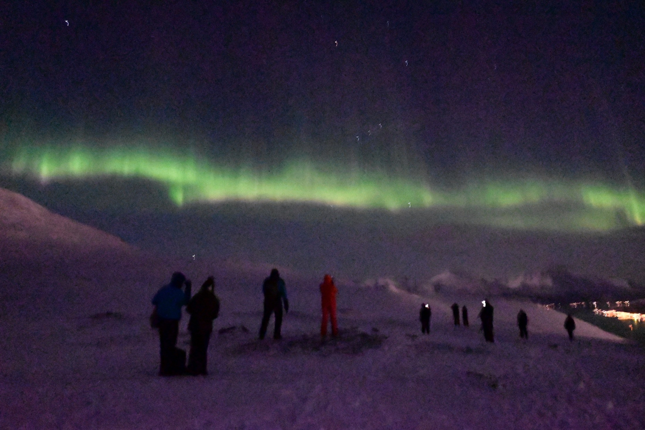 Green aurora beneath a starry night sky