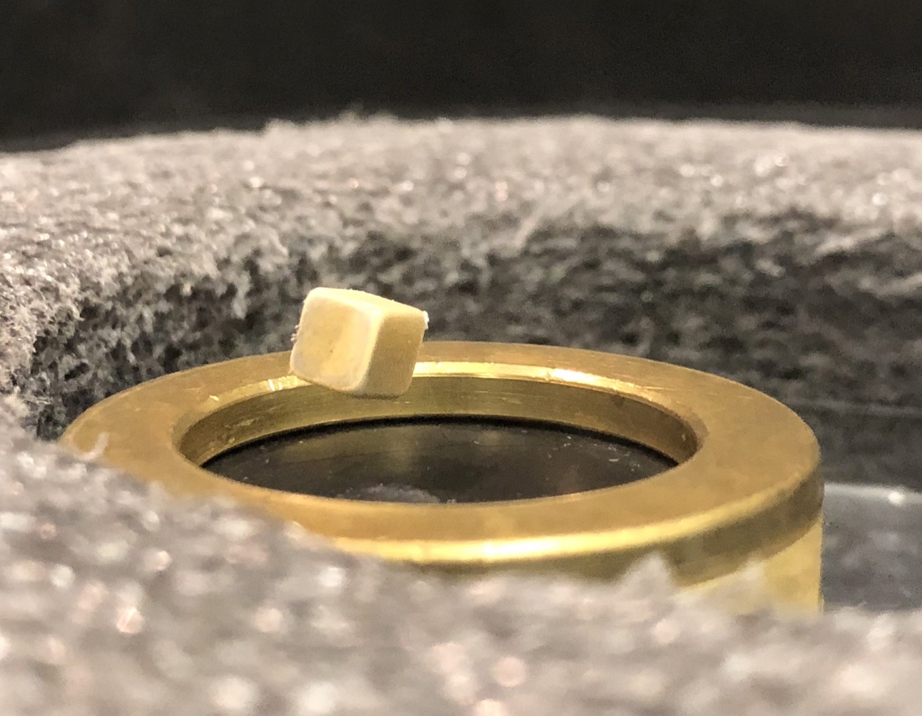 A gold-coloured experimental sample mounted inside laboratory apparatus